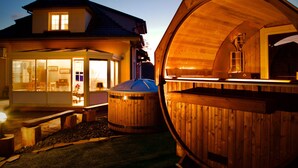A wooden cabin with a large open porch and a hot tub. - Magnificent Retreat in Vosges: Sauna, Hot Tub, Park, and More! (Colroy-la-Grande)