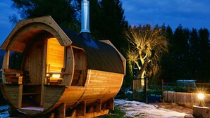 A wooden cabin with a chimney, built-in seating, and a snow-covered ground. - Magnificent Retreat in Vosges: Sauna, Hot Tub, Park, and More! (Colroy-la-Grande)
