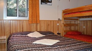 A room with a bunk bed, a window with curtains, a wall-mounted lamp, and a framed picture. - T2 Apartment at the foot of the slopes with parking (Les Angles)