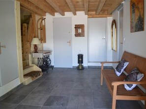 Een kamer met een houten bankje, een naaimachine, een deur en een wandradiator.