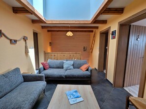 Una habitación acogedora con un sofá, una mesita de centro y una estructura de techo de madera.