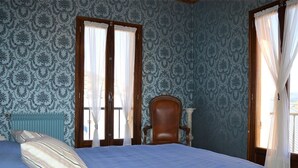 Un dormitorio con cama, una silla y un radiador.