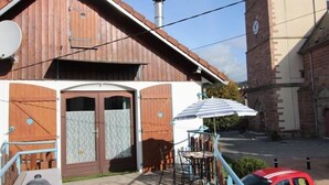 A wooden building with a brown door and a satellite dish.