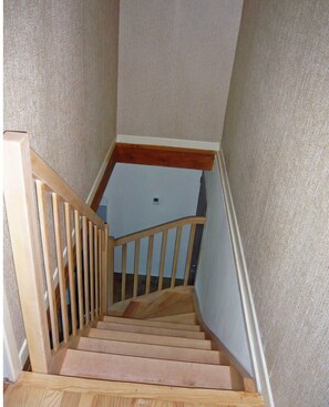 Staircase leads to an upper floor with carpeted steps and a handrail.