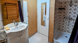 A bathroom with a white sink, mirror, and shower. - Charming Renovated Farmhouse, Near Ski Resorts & Hiking Trails, All-Inclusive, Close to Amenities (Le Syndicat)
