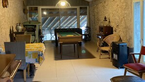 A cozy room with a pool table, wicker furniture, and a vintage radio.
