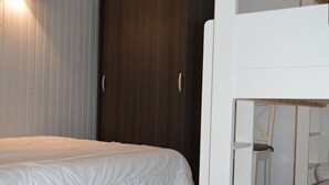 A room with a bunk bed, a wooden desk, and a wardrobe. - T2 Apartment with balcony, equipped kitchen, parking (Les Angles)