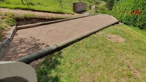 A dirt path leading to a stone structure in a green, hilly area. - Charming Mountain Cottage with Ski Access, WiFi, and Family Amenities in La Bresse (La Bresse)