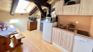 A compact kitchen with wooden cabinets, a microwave, and a sink. - Charming studio in farmhouse with terrace and parking - Vosges mountains (Le Menil)