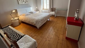 A bedroom with a bed, bedside table, lamp, chair, and a desk with a chair. - Charming Riverside Cottage with Modern Amenities & Scenic Views - 28 Rue du Charmont, Lironcourt (Lironcourt)