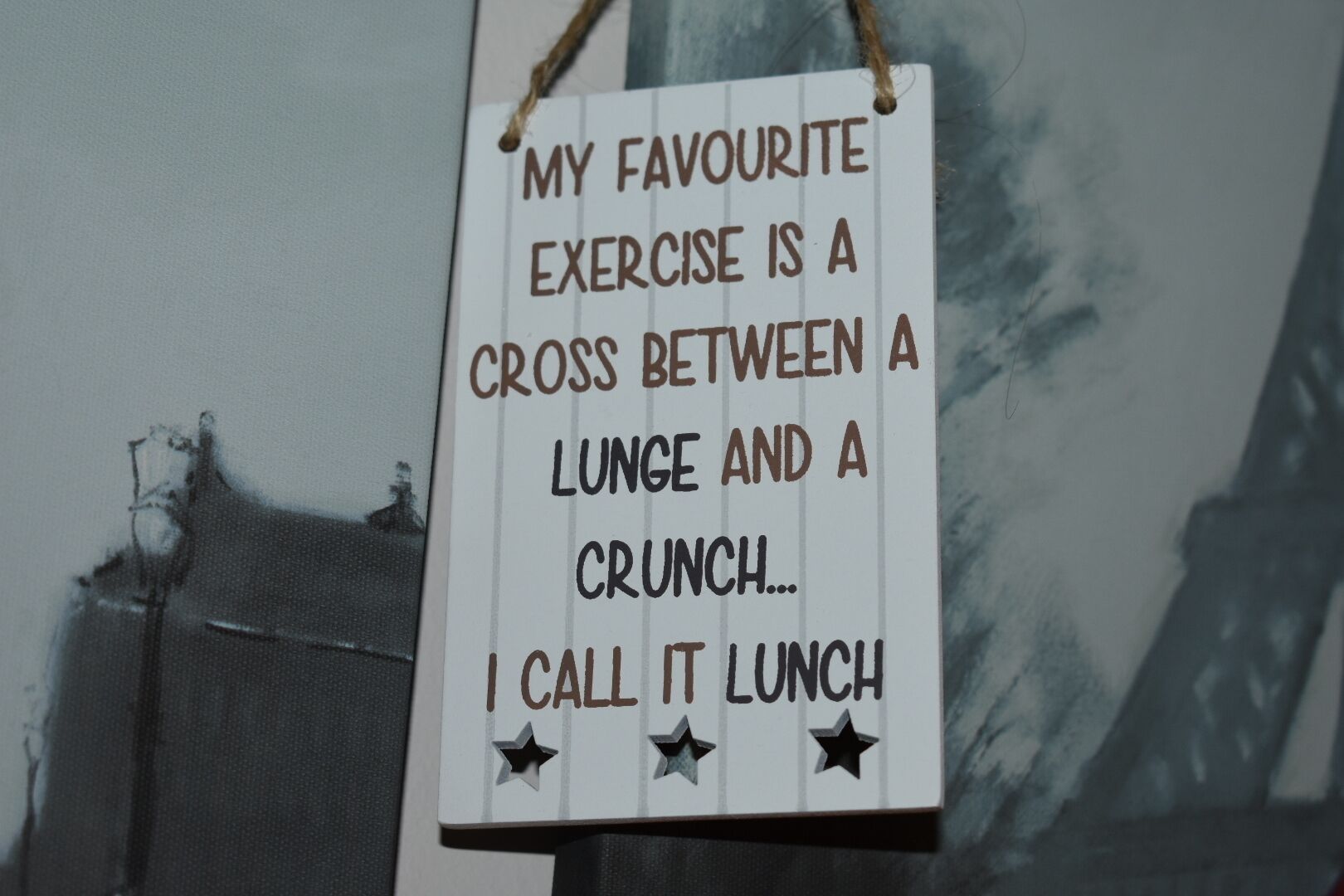 A sign with text about a favorite exercise, hung on a wall with a window in the background.