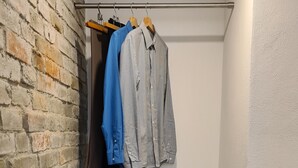 A small, modern closet with a white upper section and a grey lower section, featuring two drawers and a hanging rod with clothes. - Modern vacation apartment "wohnung-nummer-1" in rural area near Regensburg (Pielenhofen)