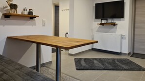 A modern living room with a wooden table, a mounted TV, and a fireplace. - Modern vacation apartment "wohnung-nummer-1" in rural area near Regensburg (Pielenhofen)