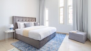Laptop workspace, iron/ironing board, bed sheets - Radiant & Cozy Studio Apartment In Sports City (Dubai)