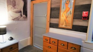 A hallway with a wooden door, a dresser with drawers, and two framed artworks on the wall. - Immaculate 1-bed Apartment in Blackpool - Sleeps 5 (Blackpool)