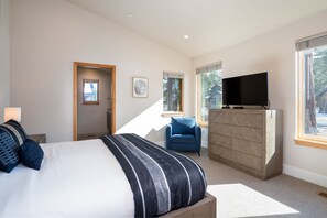 Une chambre à coucher avec un lit, une commode, une télévision et une chaise.