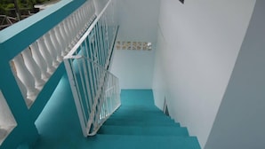 A staircase with teal steps and white railings. - Veronica's - Breathe Easy - Reduit Apartment #1 (Rodney Bay)