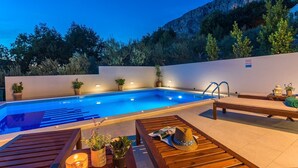 A swimming pool with a wooden deck, lounge chairs, and potted plants. - Seaview Villa Lemaro, a 2-bedroom villa with a 28 sqm private pool in Krilo Jesenice (Jesenice)