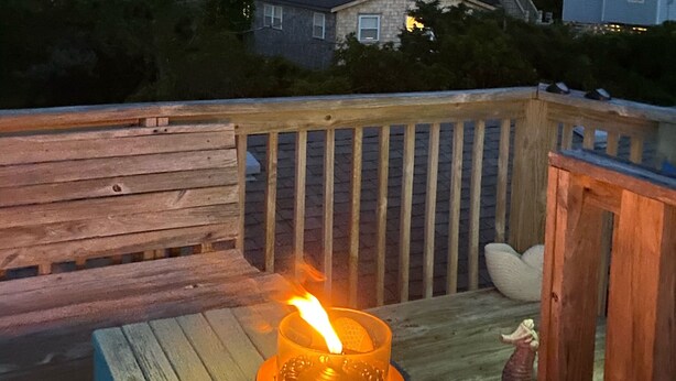A wooden deck with a table, a candle, and a bowl of snacks. - Salvo Sandbox: Ocean-Side, Dog-Friendly Cottage (Salvo)