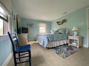 A bedroom with a bed, a chair, a television, and a window. - Salvo Sandbox: Ocean-Side, Dog-Friendly Cottage (Salvo)