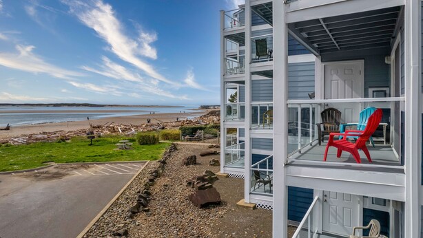 A multi-story building with a balcony overlooking a beach.