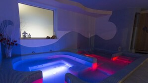 Ein moderner Wellnessbereich mit einer großen Whirlwanne, einem Fenster mit Aussicht und einem gefliesten Boden.