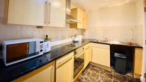 Een moderne keuken met een magnetron, broodrooster en spoelbak.