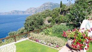 Un jardín con vistas al mar y a las montañas.
