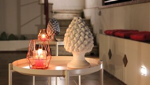 A round table with a white vase and a candle in a geometric holder. - Duke of Aosta Terrace with private mini-pool (Acquedolci)