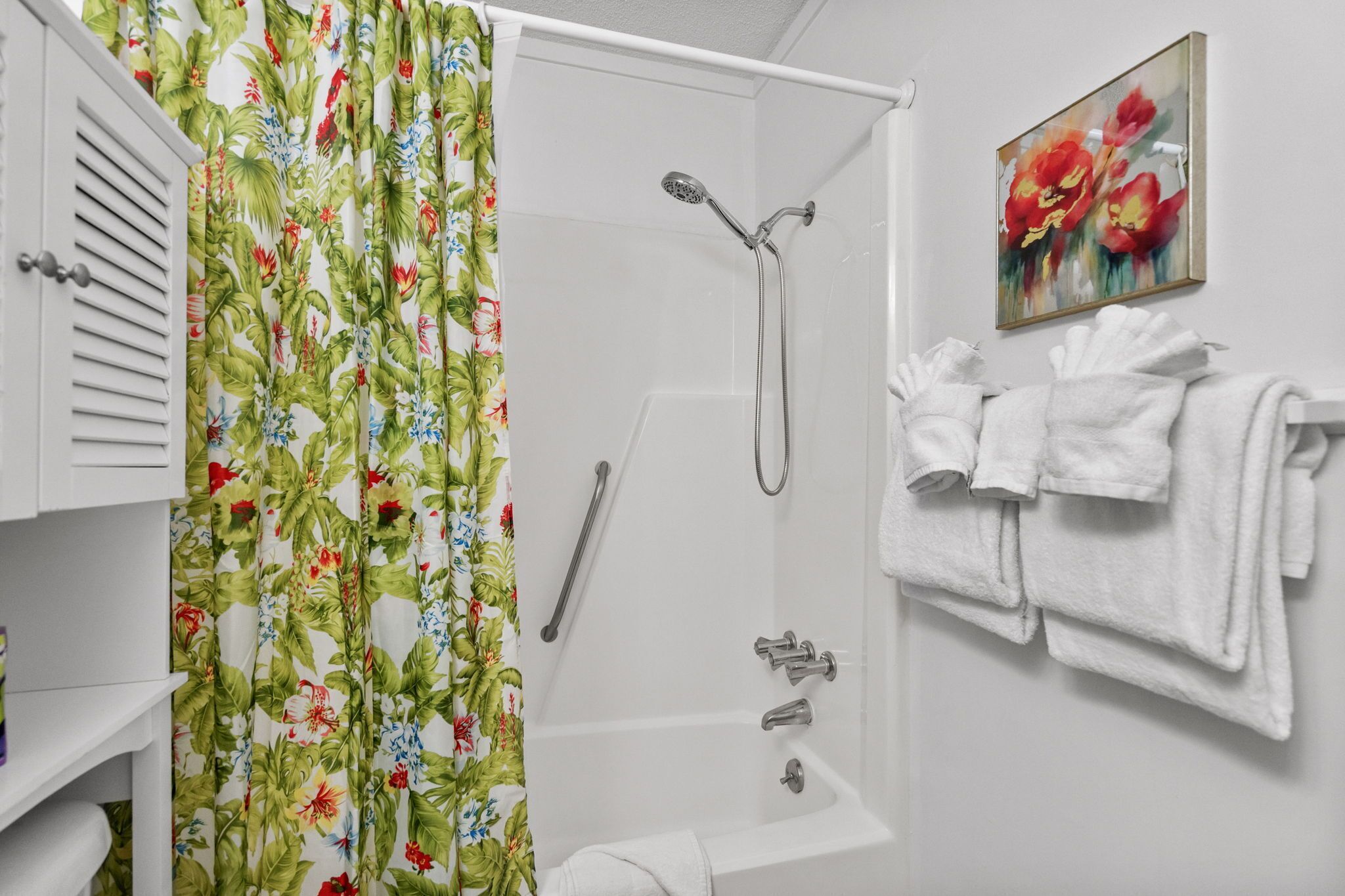 A bathroom with a shower, a toilet, a sink, and a towel rack with towels.
