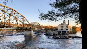 Un pont enjambant une rivière, avec un bâtiment situé sur la droite.