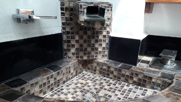 A bathroom with a mosaic tile floor and walls, a metal sink, and a shower area. - CIUDAD DE MEXICO UNAM GUEST HOUSE (Ciudad de México)