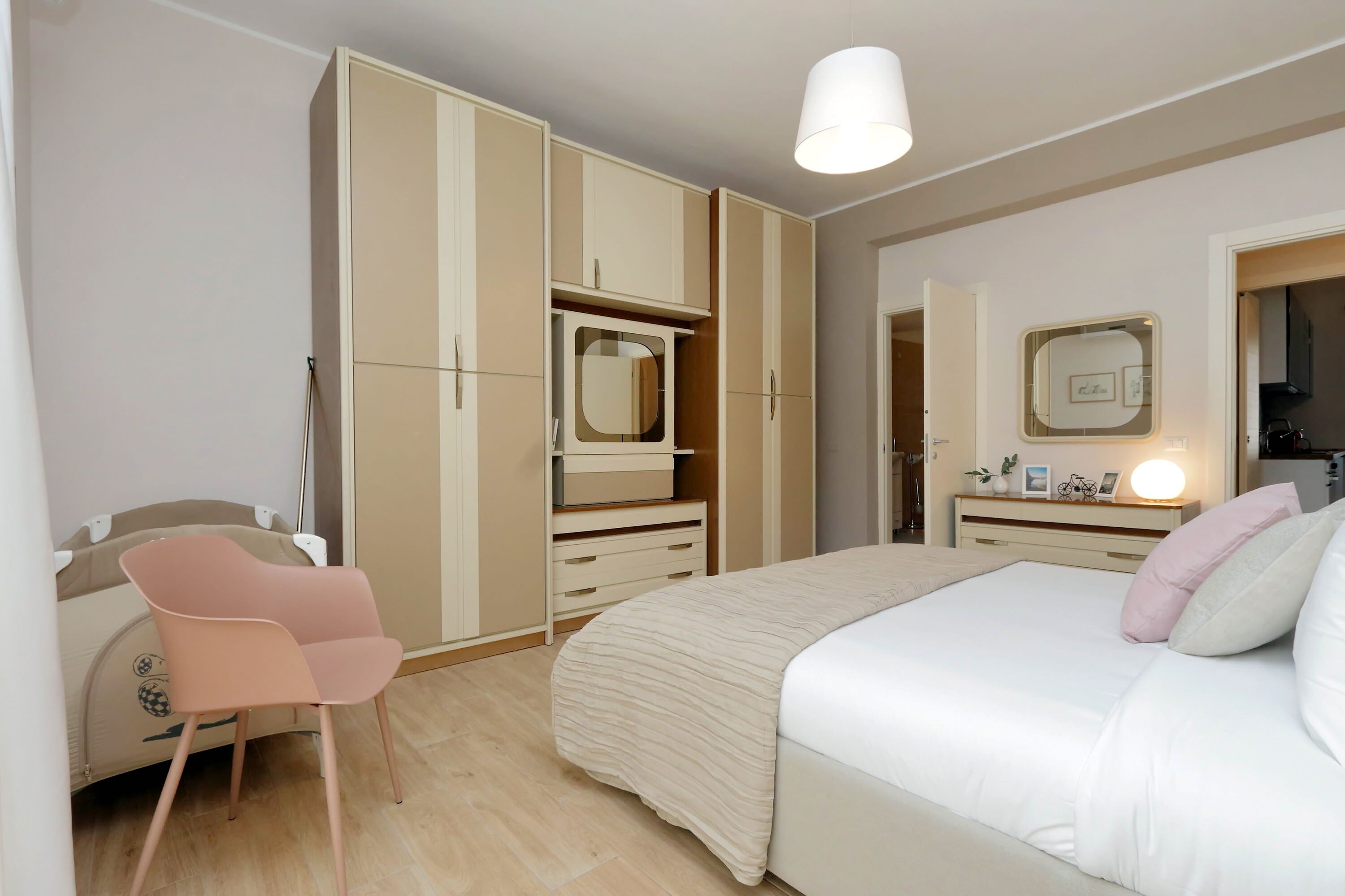 Une chambre à coucher comprenant un lit, un bureau avec une chaise et une armoire.