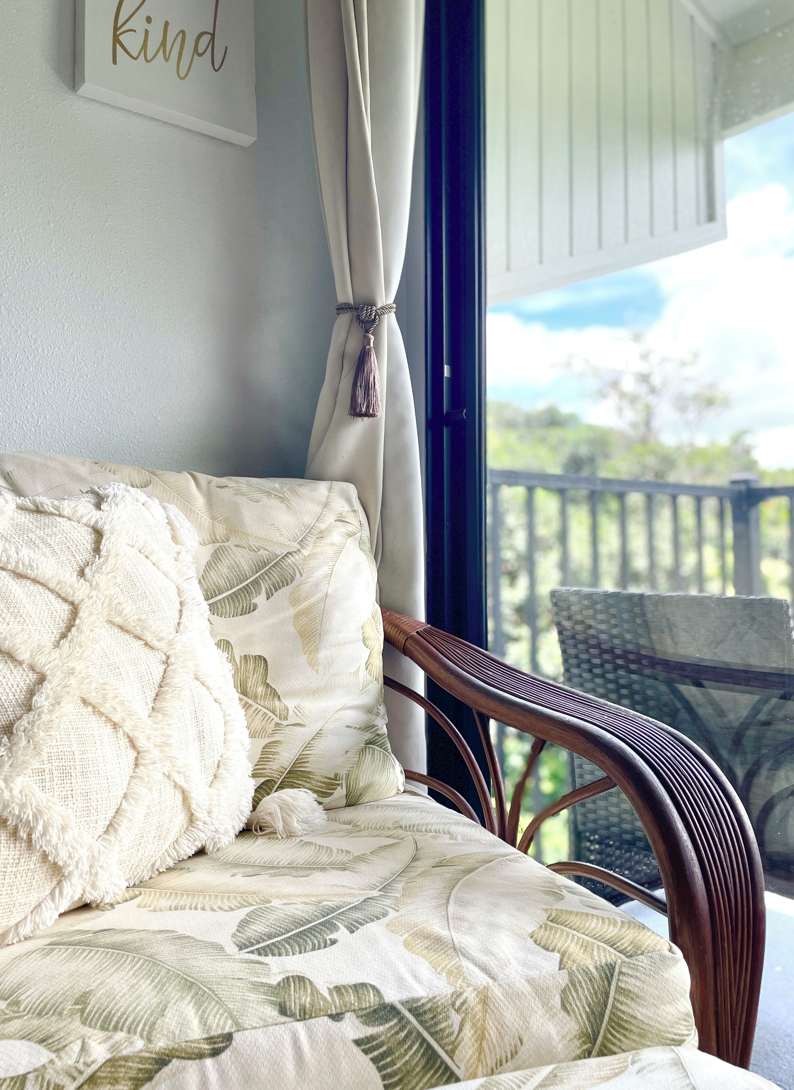 Una stanza con un letto, una sedia, una finestra con tende e vista sull'esterno.