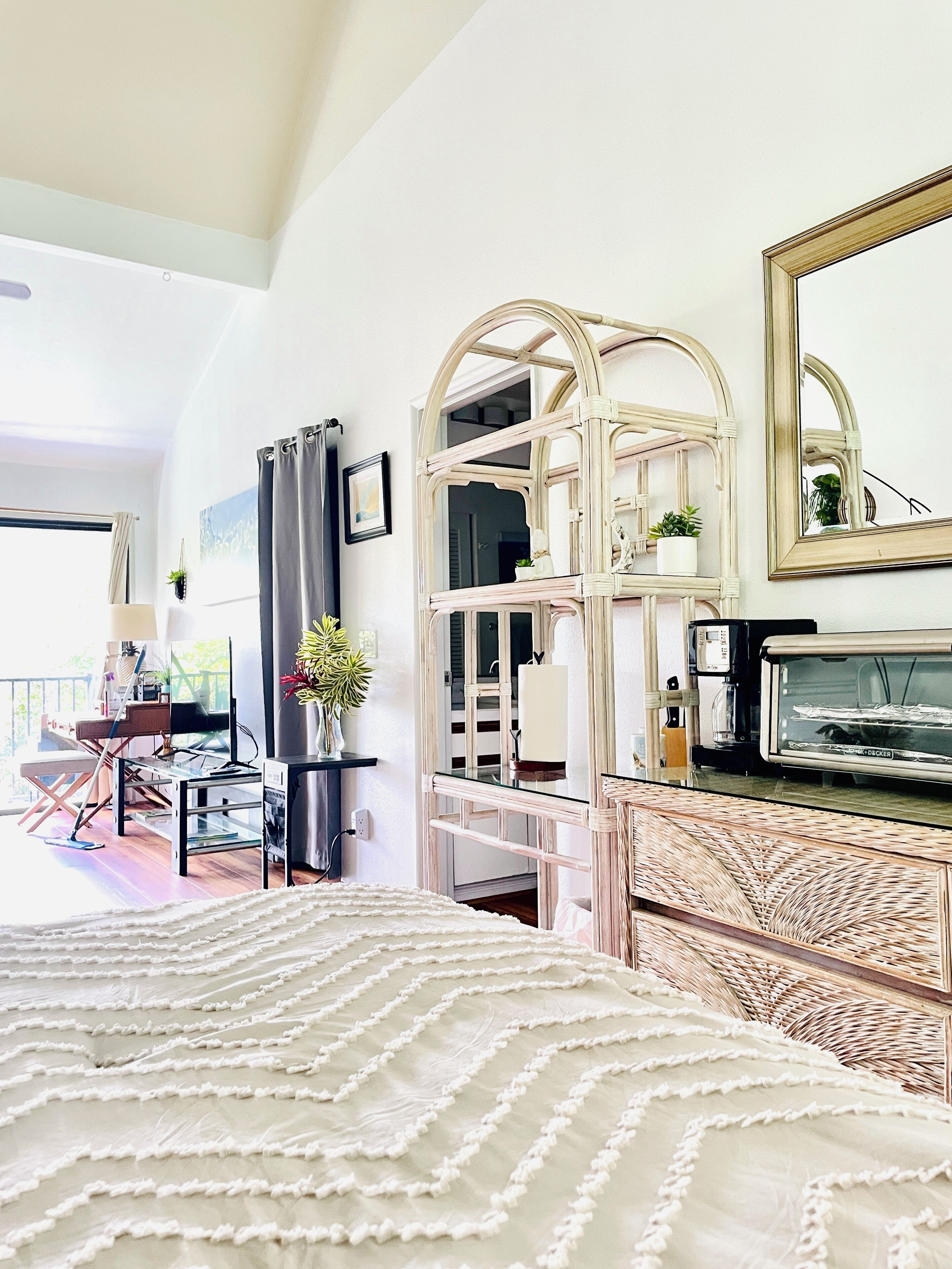 Une chambre d’hôtel avec un lit, une télévision, un miroir et un balcon offrant une vue.