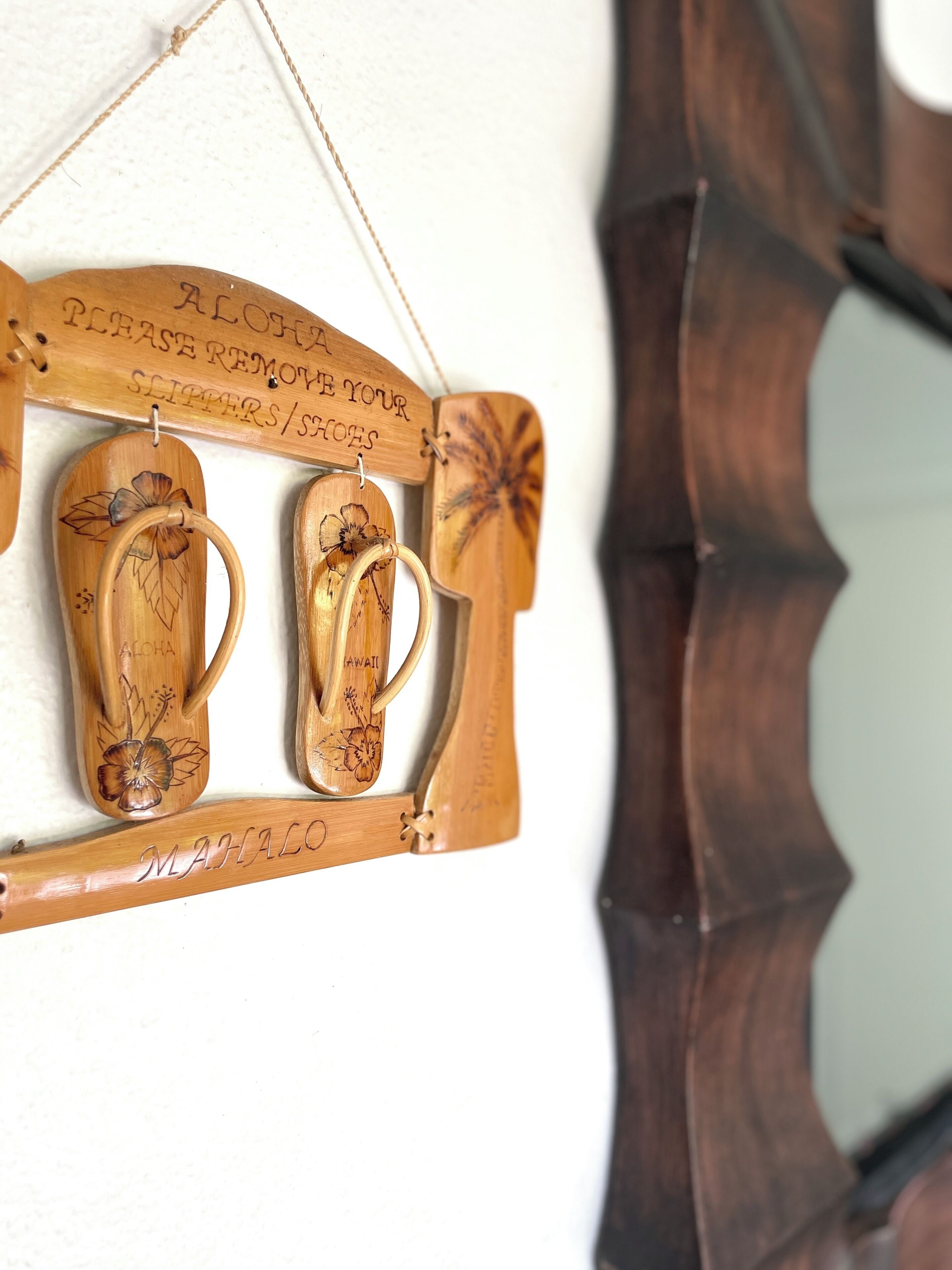 A wooden wall decoration with two wooden cups and a sign above them.