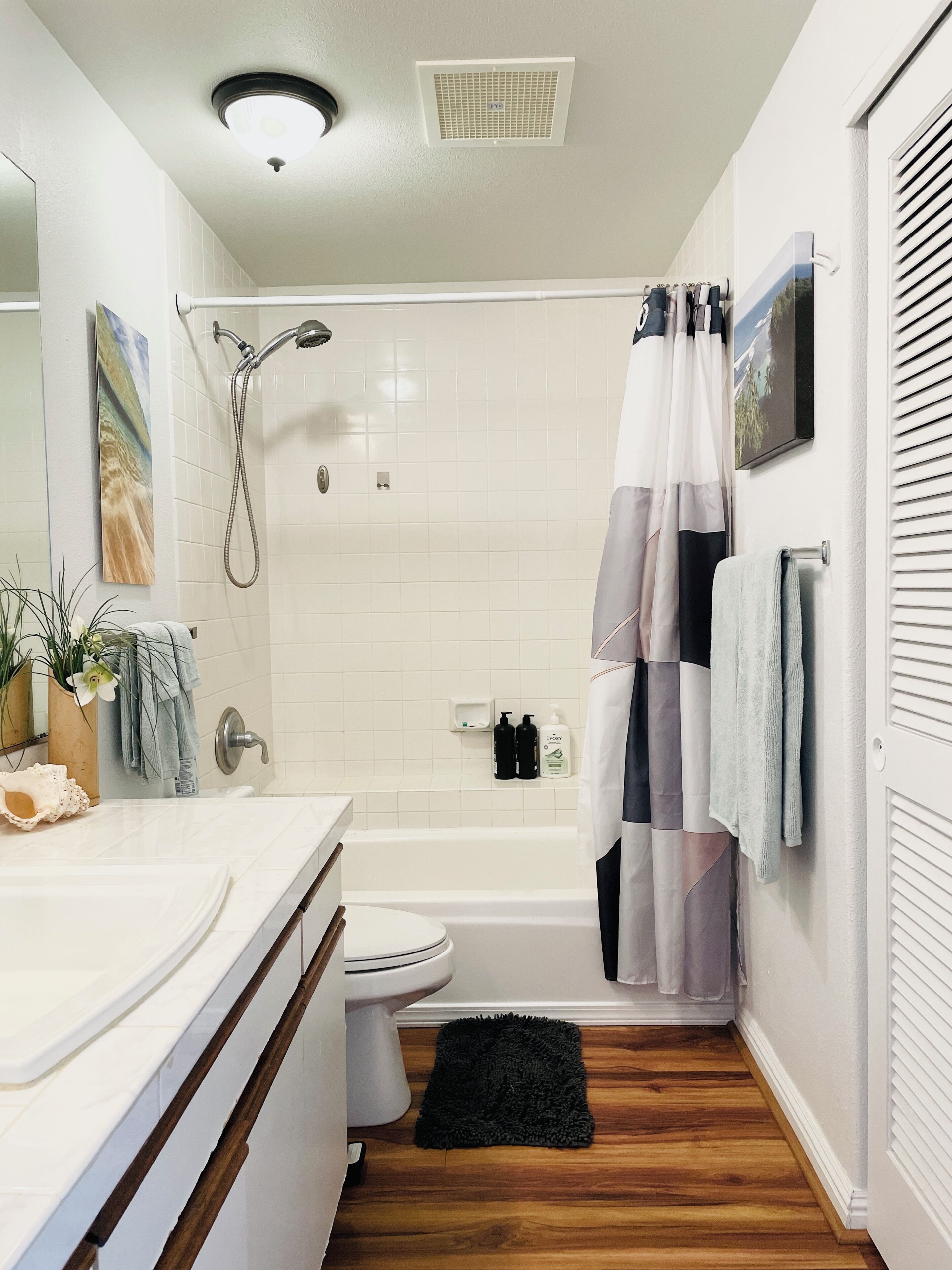 A bathroom with a shower, toilet, and sink.