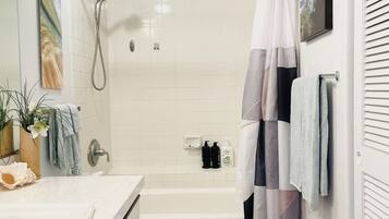 A bathroom with a shower, toilet, and sink.