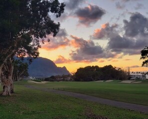 A golf course with a path, trees, and a mountain in the background. - Tropical, Bright Princeville Studio with Mountain Views (Princeville)