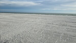 A beach with visible tire tracks and footprints in the sand. - BRAND NEW 16x14 Heated Swim Jacuzzi Sleeps 8 Beach Front! No Condo Park 4 Cars! (Fort Myers Beach)