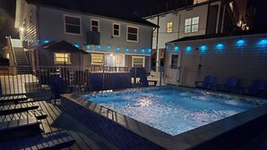 A hot tub surrounded by deck chairs and a covered patio area. - BRAND NEW 16x14 Heated Swim Jacuzzi Sleeps 8 Beach Front! No Condo Park 4 Cars! (Fort Myers Beach)