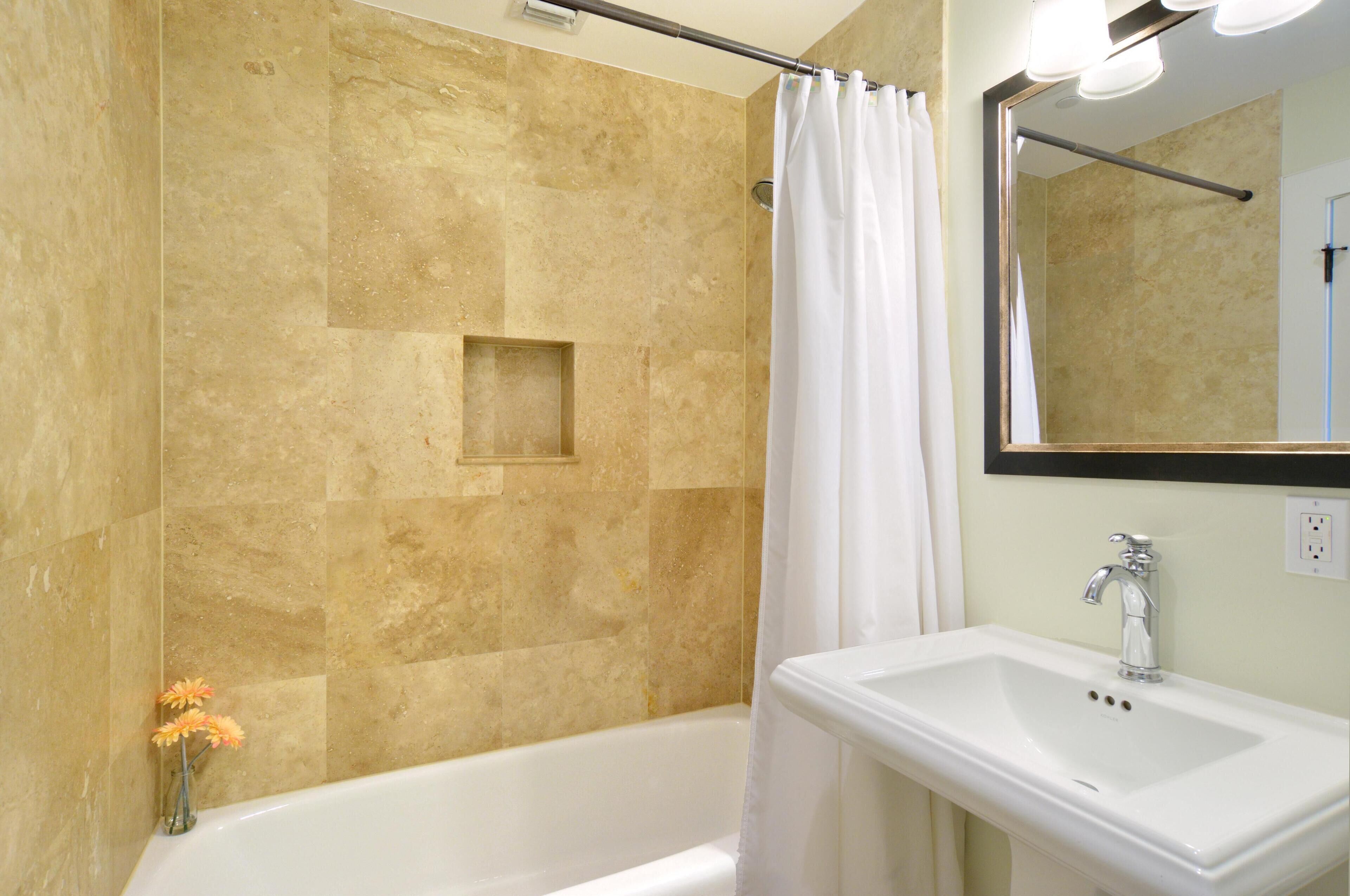 Une salle de bain avec une baignoire, un lavabo et un miroir.