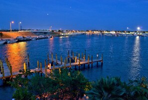 A marina at dusk with boats docked, wooden piers, and a distant cityscape. - Island Chi c (Key West)