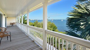 A covered porch with white railings and a view of the sea. - Southern Comfor t (Key West)