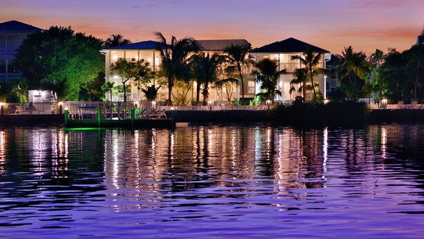 A waterfront hotel with a pool, palm trees, and a sunset. - Bayview Middle (Key West)
