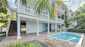 Une maison à deux étages dotée d’un patio couvert et d’une piscine.