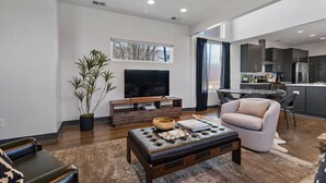 A modern living room with a flat-screen TV, a coffee table, and a comfortable sofa. - Immaculate Meets Comfort! 3 BR Spacious Home! (Nashville)