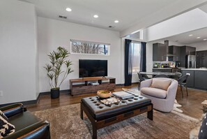 Ein modernes Wohnzimmer mit Flachbildfernseher, Couchtisch und gemütlicher Couch.