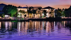 A waterfront hotel with a pool, palm trees, and a sunset. - Upper Sunset South (Key West)