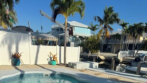Une piscine à bordures courbes, entourée d’une terrasse blanche.